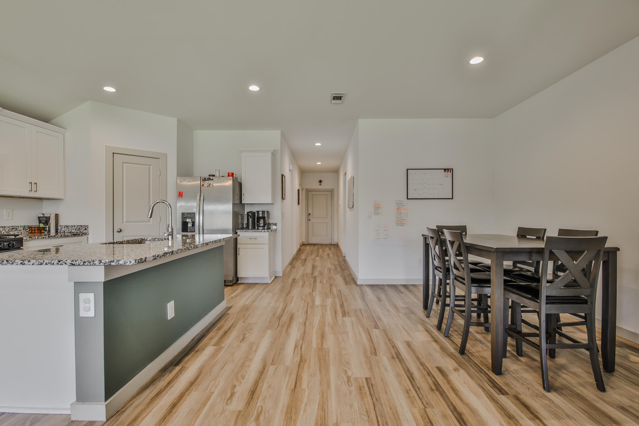 7406 9th Street Lubbock, TX 79416 - Photo 42 of 54 a kitchen with stainless steel appliances a dining table chairs and wooden floor