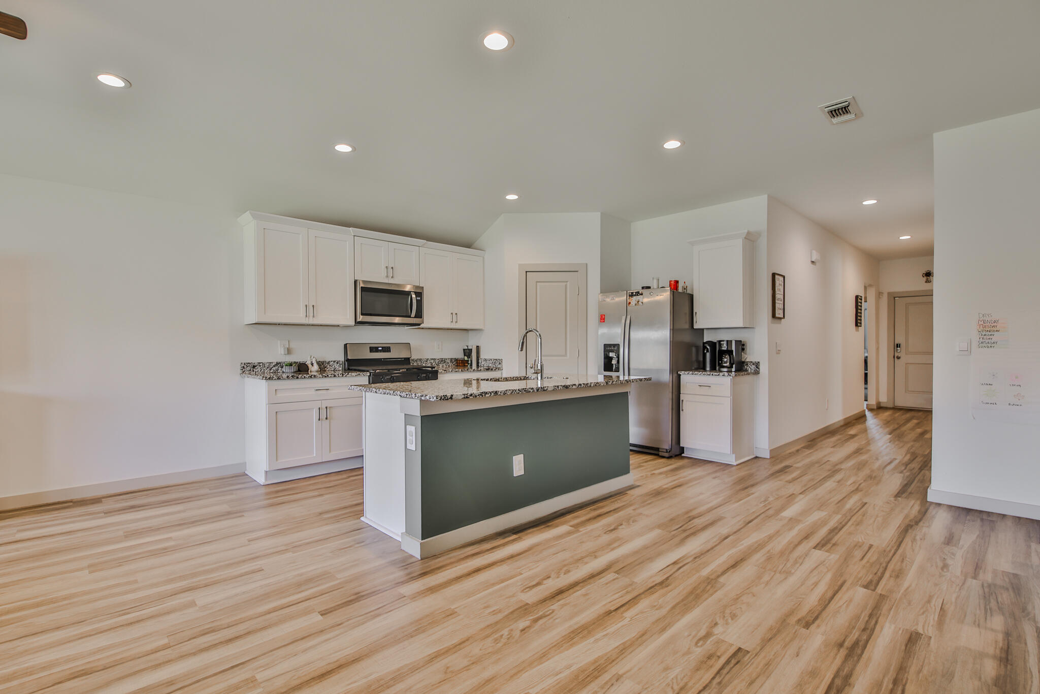 7406 9th Street Lubbock, TX 79416 - Photo 43 of 54 a large kitchen with cabinets wooden floor and stainless steel appliances