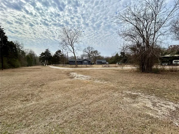 a view of dirt field with trees