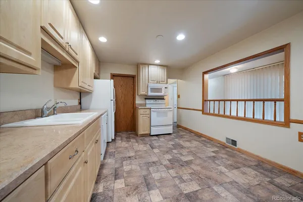 a kitchen with cabinets and a refrigerator