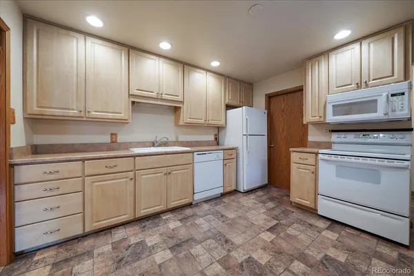 a kitchen with white cabinets and white appliances