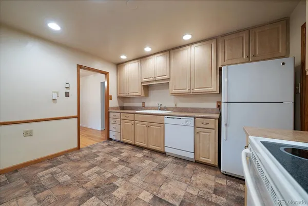 a kitchen with refrigerator cabinets and wooden floor