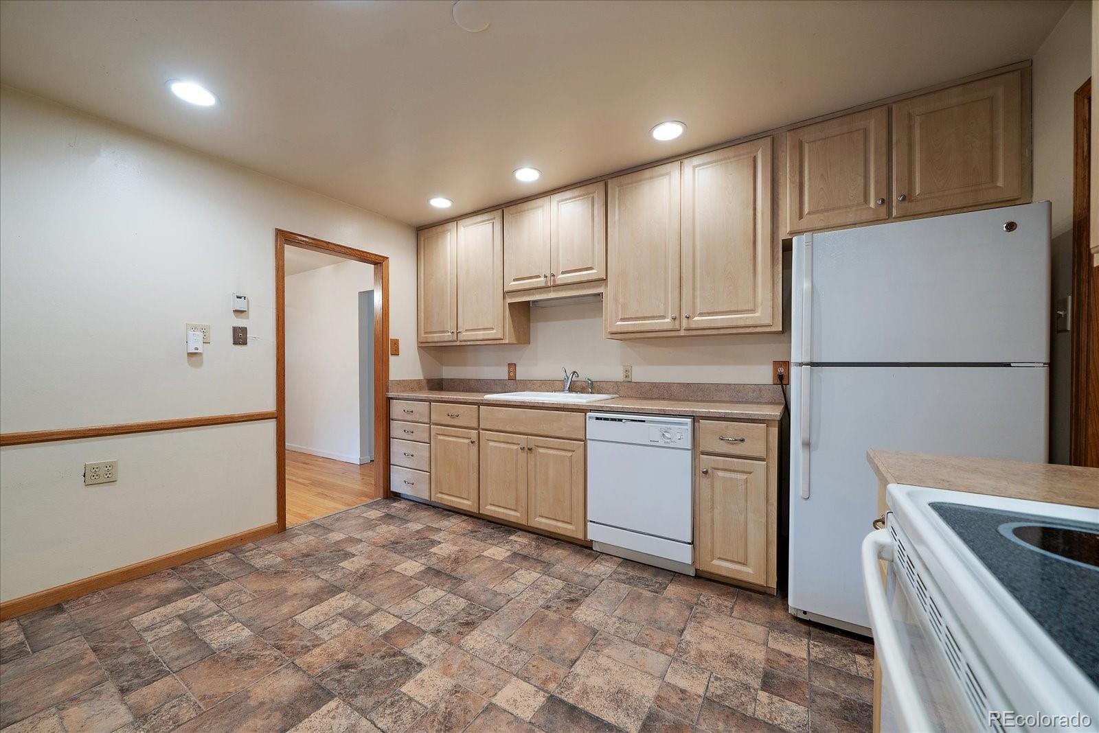 2510 South Cherry Street Denver, CO 80222 - Photo 15 of 37 a kitchen with refrigerator cabinets and wooden floor