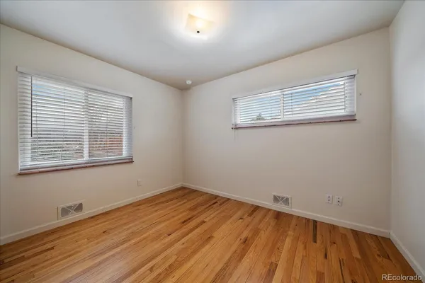 a view of a room with wooden floor and a window