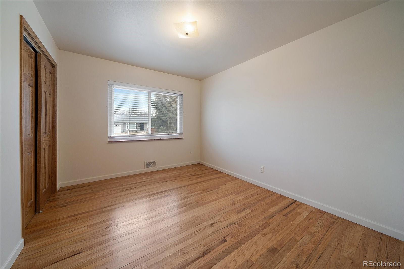 2510 South Cherry Street Denver, CO 80222 - Photo 21 of 37 an empty room with wooden floor and windows