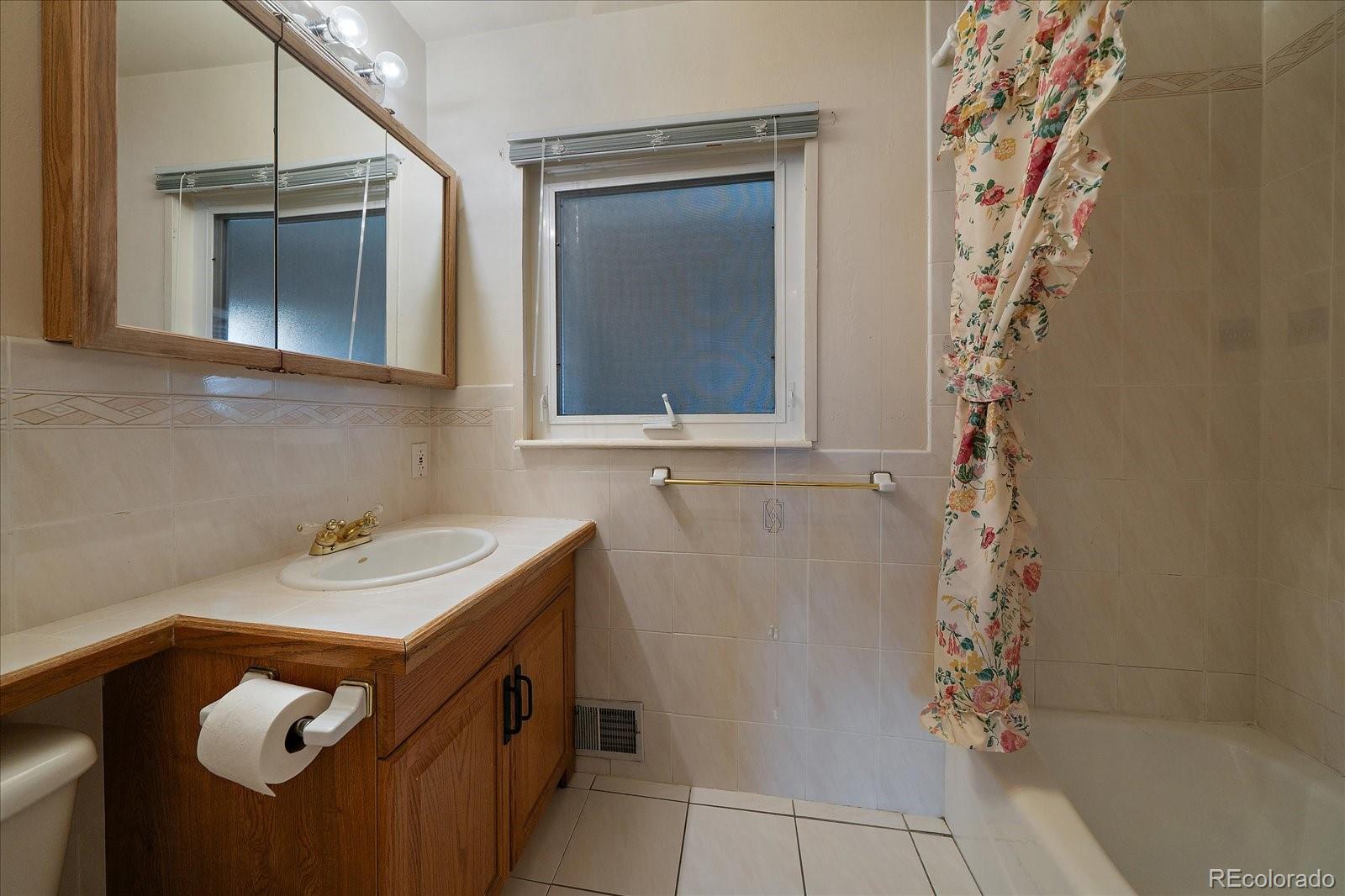 2510 South Cherry Street Denver, CO 80222 - Photo 22 of 37 a bathroom with a sink a mirror and shower