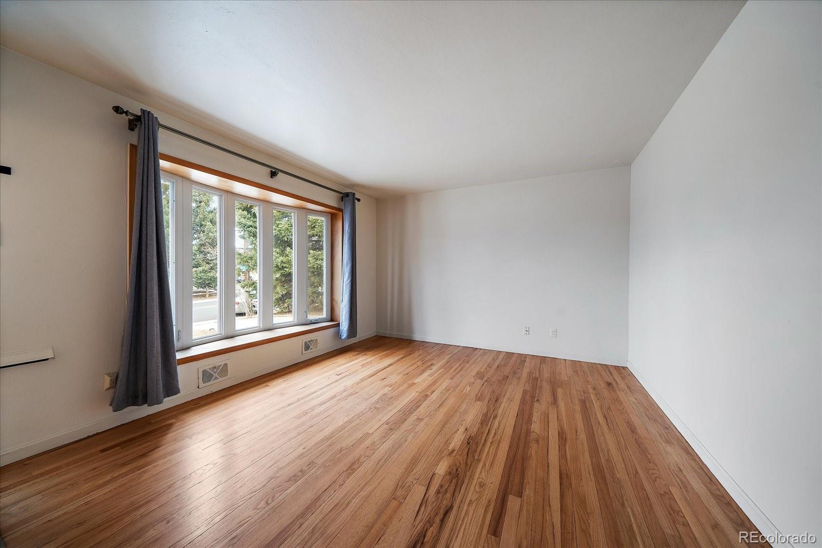 2510 South Cherry Street Denver, CO 80222 - Photo 9 of 37 a view of an empty room with wooden floor and a window