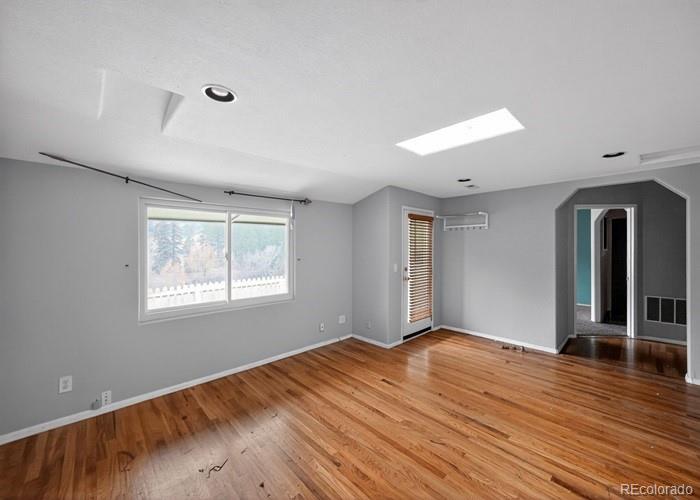 6498 South Turkey Creek Road Morrison, CO 80465 - Photo 5 of 19 a view of an empty room with wooden floor and a window