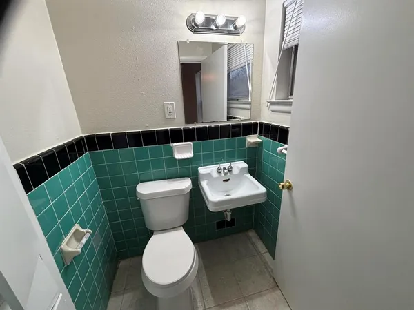 a bathroom with a toilet a sink and mirror