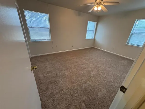 an empty room with a chandelier fan