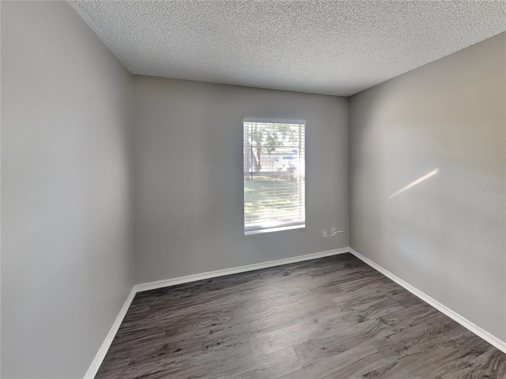 Undisclosed Address Deltona, FL 32738 - Photo 14 of 18 an empty room with wooden floor and windows