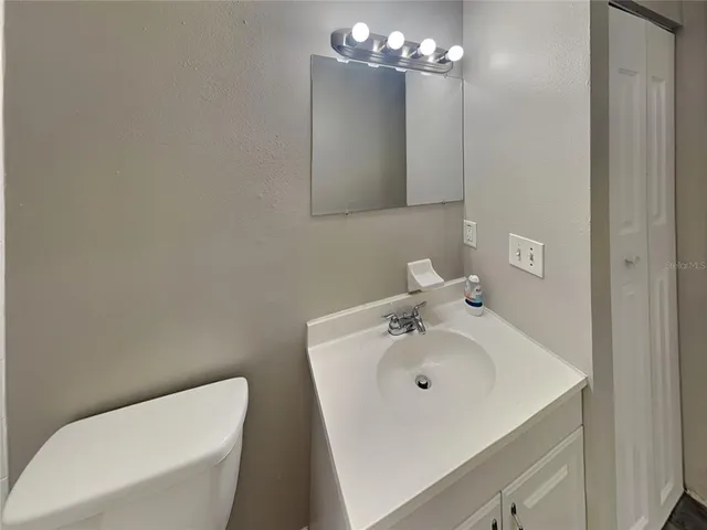a bathroom with a sink a toilet and mirror