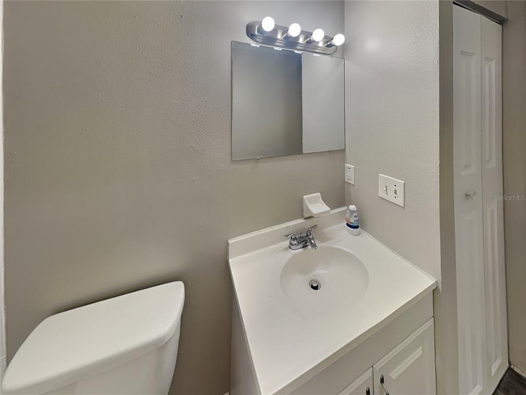 Undisclosed Address Deltona, FL 32738 - Photo 16 of 18 a bathroom with a sink a toilet and mirror