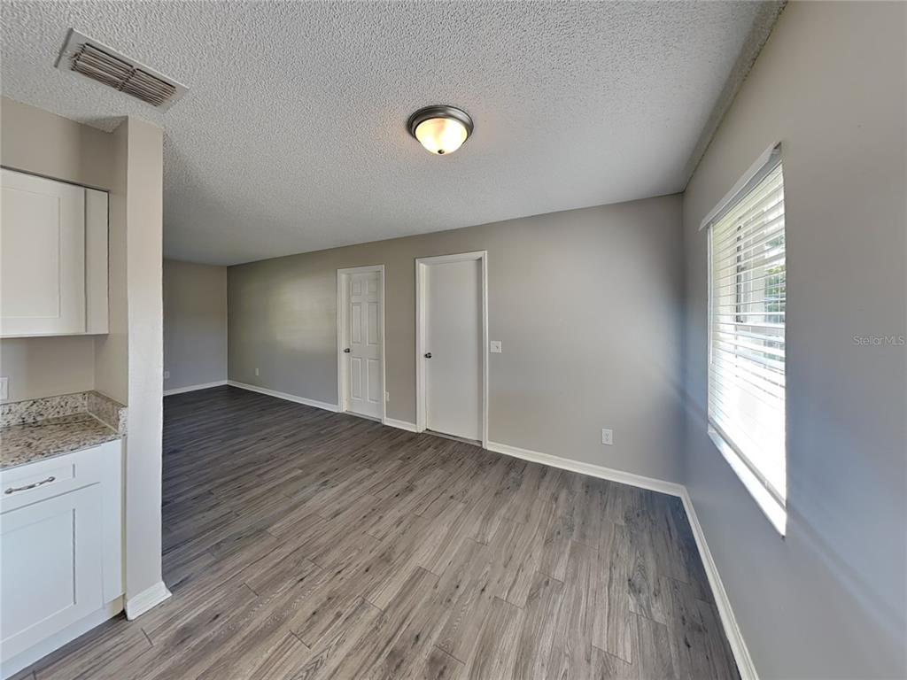Undisclosed Address Deltona, FL 32738 - Photo 4 of 18 a view of an empty room with wooden floor and a window