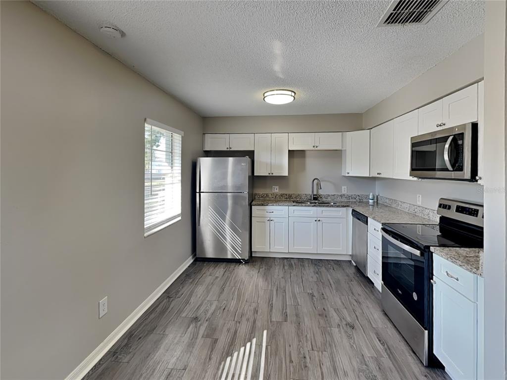 Undisclosed Address Deltona, FL 32738 - Photo 5 of 18 a kitchen with granite countertop a refrigerator stove top oven and sink