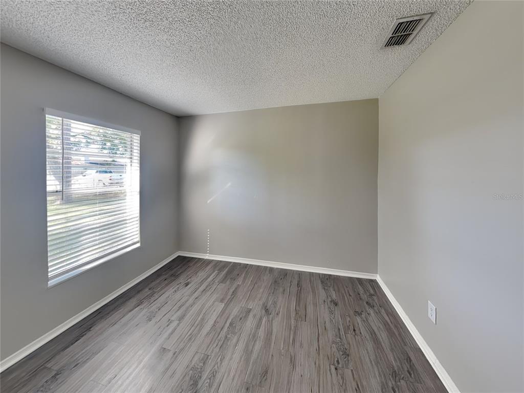 Undisclosed Address Deltona, FL 32738 - Photo 6 of 18 an empty room with wooden floor and windows
