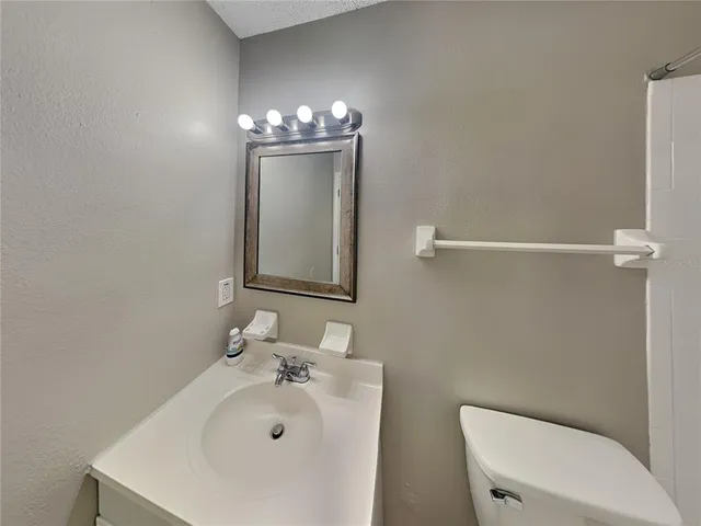 a bathroom with a sink a toilet and mirror
