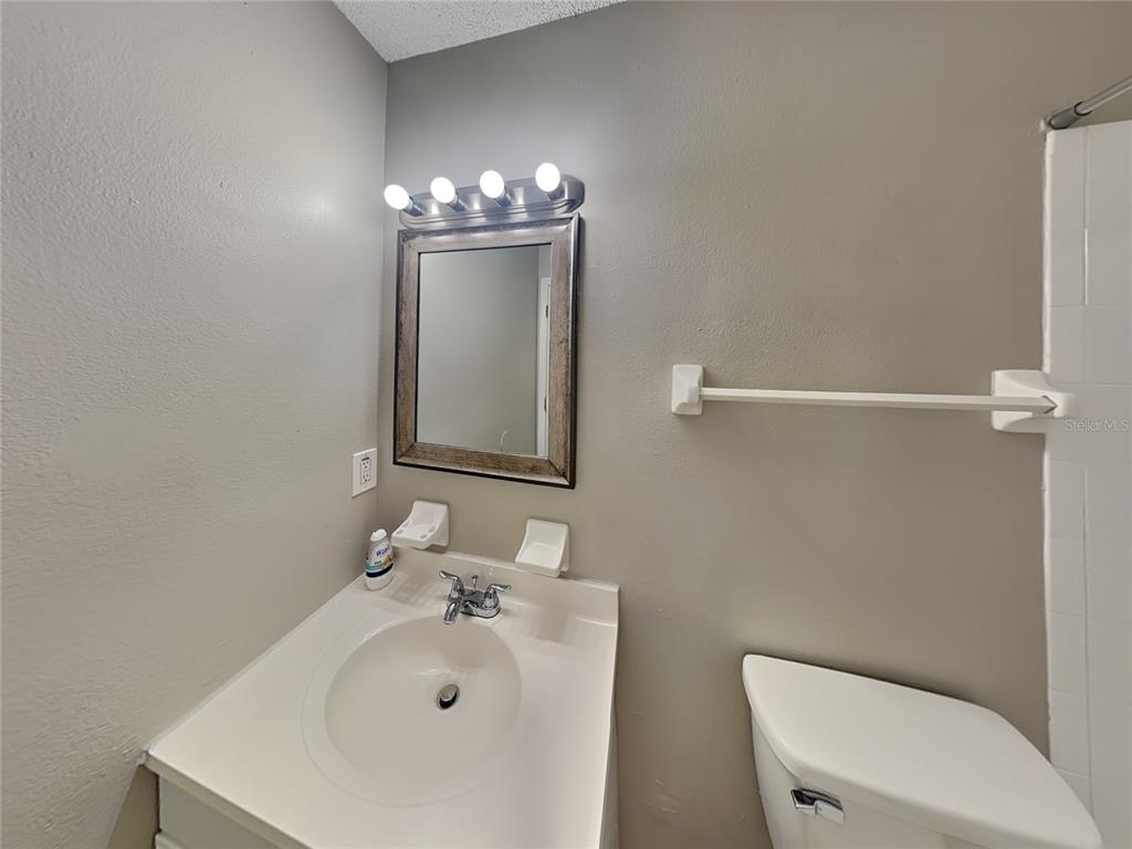 Undisclosed Address Deltona, FL 32738 - Photo 8 of 18 a bathroom with a sink a toilet and mirror