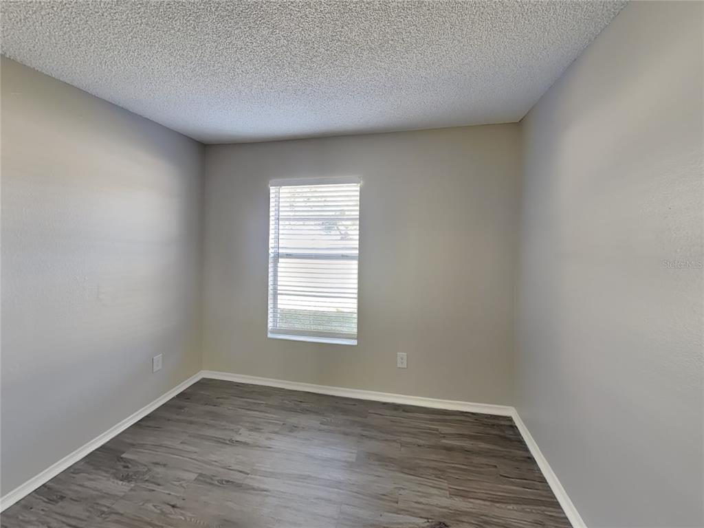 Undisclosed Address Deltona, FL 32738 - Photo 10 of 18 an empty room with wooden floor and window