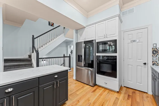 a kitchen with stainless steel appliances kitchen island granite countertop a refrigerator and a sink