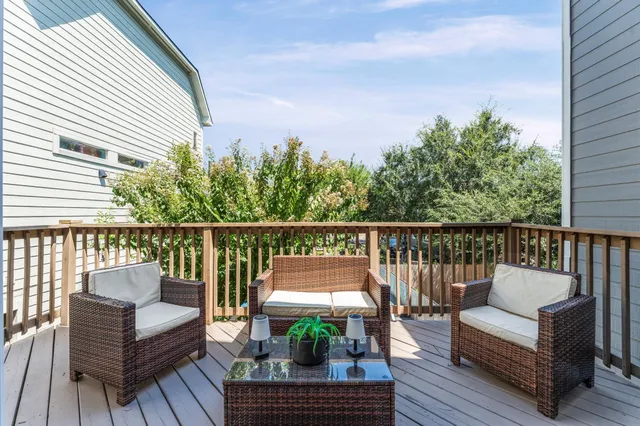 a view of a balcony with wooden floor and outdoor seating