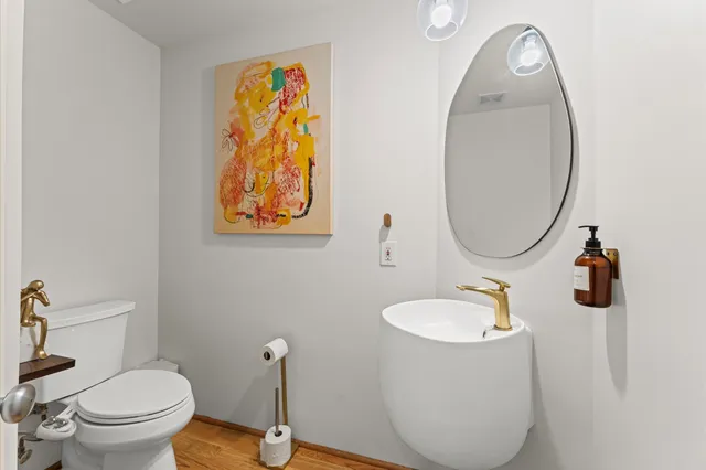 a bathroom with a toilet a sink and mirror