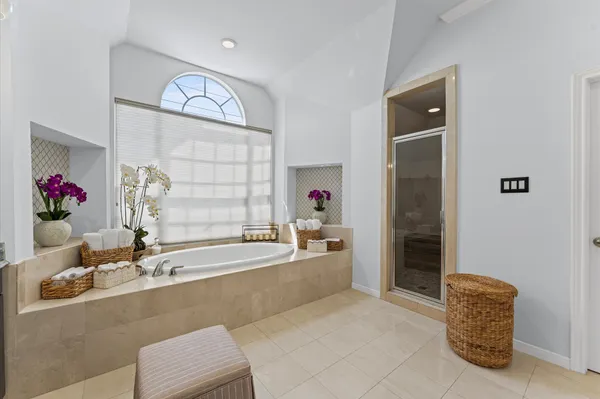 a large bathroom with a tub sink and mirror