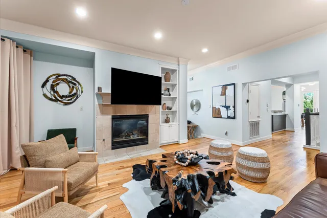 a living room with furniture a flat screen tv and a fireplace