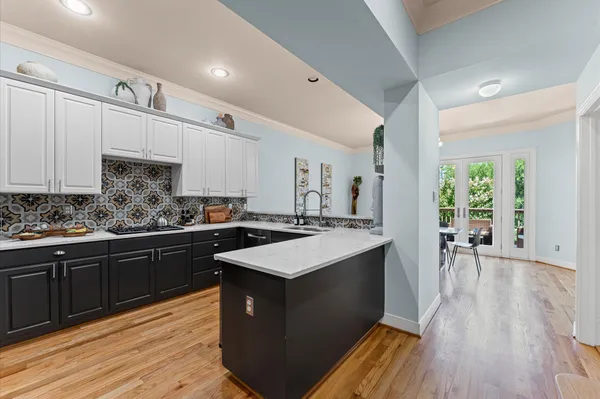 a kitchen with stainless steel appliances granite countertop a stove a sink dishwasher and a refrigerator with wooden floor