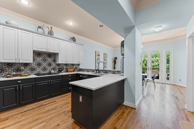 a kitchen with stainless steel appliances granite countertop a stove a sink dishwasher and a refrigerator with wooden floor