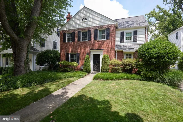 a front view of a house with a yard and trees