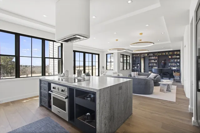 a dining hall with stainless steel appliances granite countertop a stove and a large window