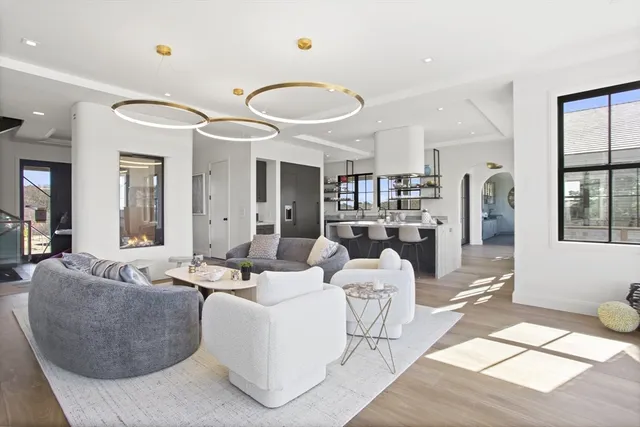 a living room with furniture kitchen view and large windows