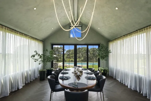 a dining room with furniture and a floor to ceiling window