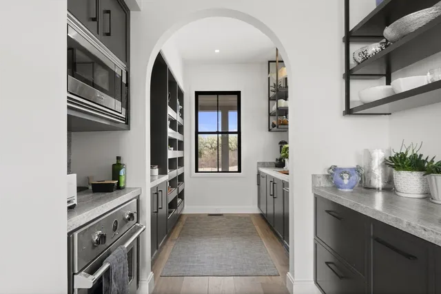 a kitchen with granite countertop a sink and dishwasher a oven with wooden floor