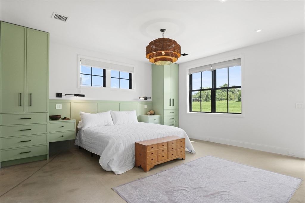 10 Maxey Pond Road Nantucket, MA 02554 - Photo 29 of 35 a bedroom with a bed and a chandelier