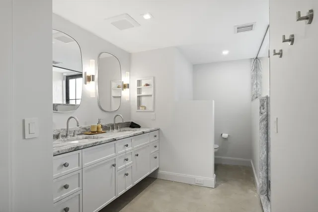 a spacious bathroom with a double vanity sink a mirror and shower