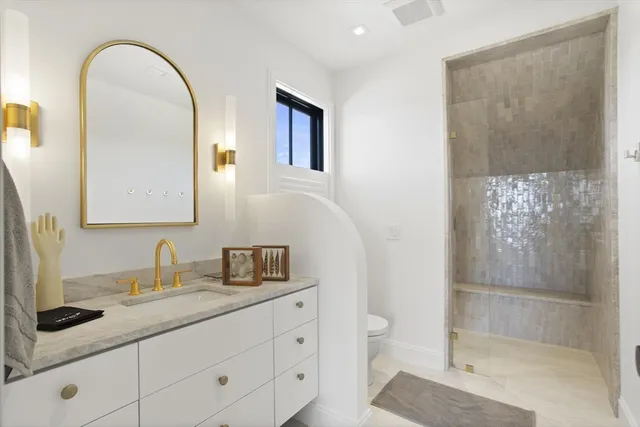 a bathroom with a granite countertop sink a toilet and a mirror