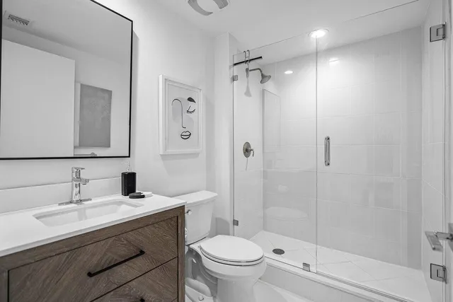 a bathroom with a sink toilet vanity and shower