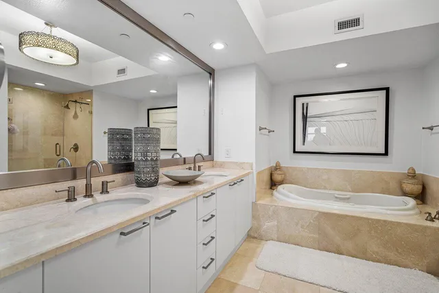 a bathroom with a double vanity sink tub and mirror
