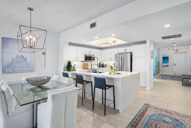 a kitchen with a sink and chairs