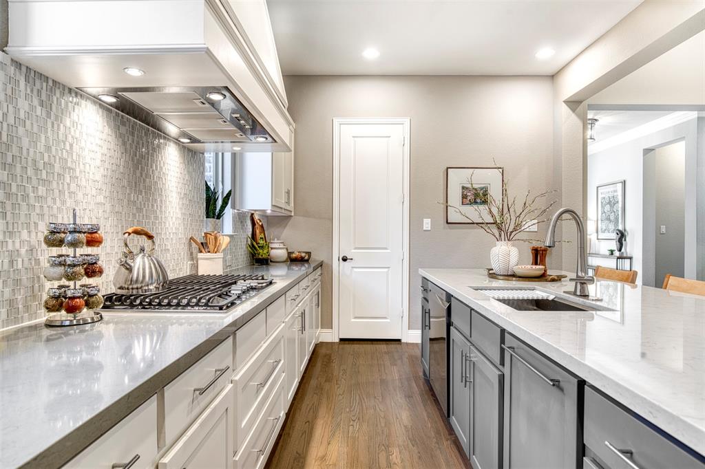 5904 Rutland Road McKinney, TX 75070 - Photo 12 of 40 Dual tone kitchen with two tone cabinets, light stone countertops, dark wood-style flooring, recessed lighting, and tasteful backsplash