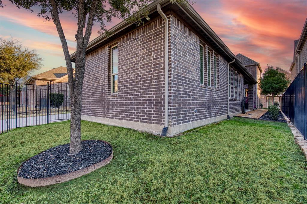 5904 Rutland Road McKinney, TX 75070 - Photo 29 of 40 Property exterior at dusk with a fenced backyard and brick siding