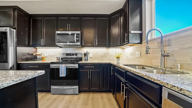 a kitchen with granite countertop stainless steel appliances and wooden cabinets