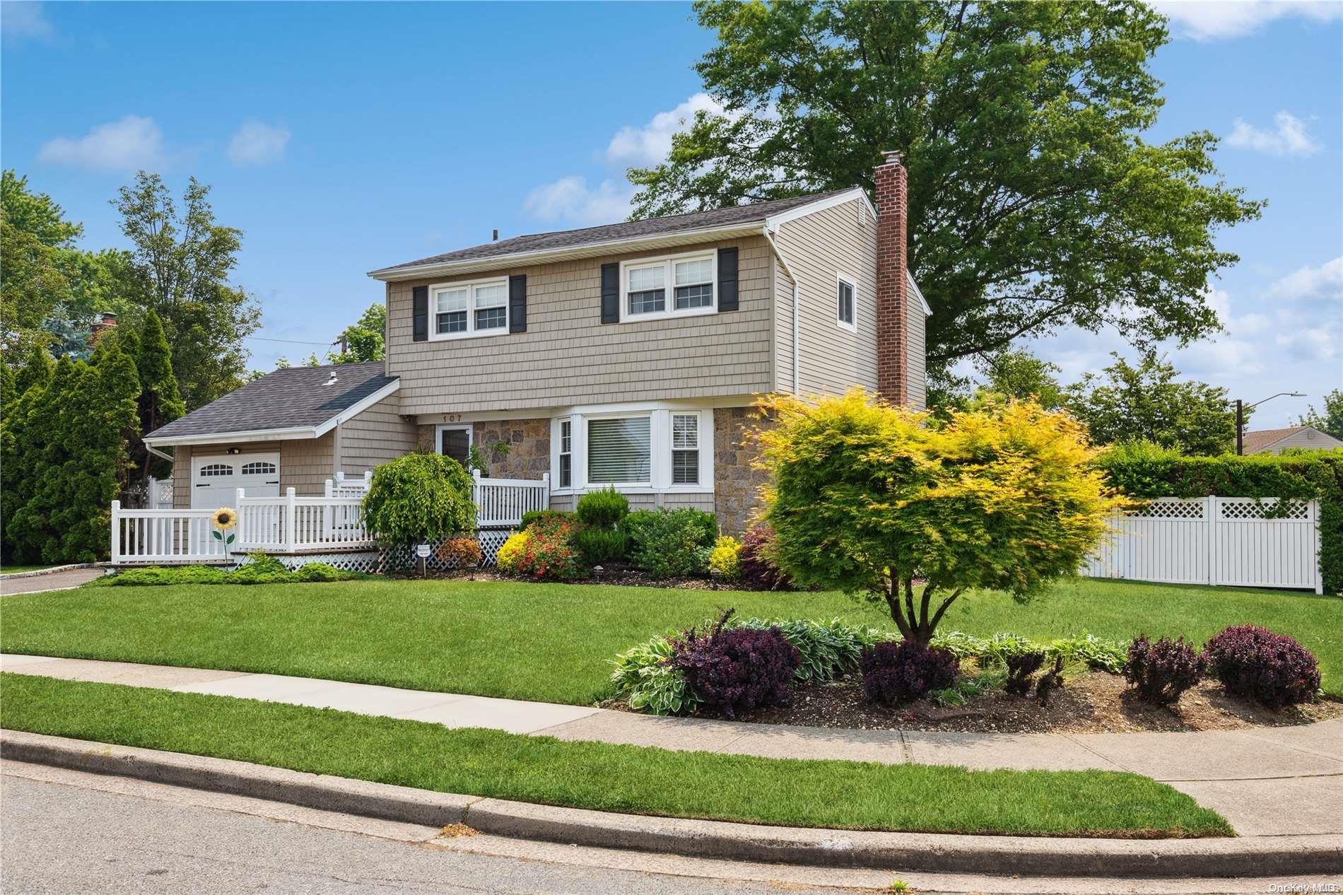 107 Wayne Street Jericho, NY 11753 - Photo 1 of 1 a front view of a house with a yard and potted plants
