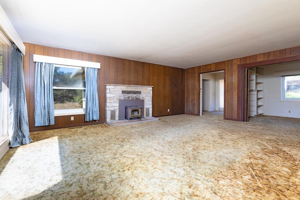 417 Maher Road Watsonville, CA 95076 - Photo 6 of 37 an empty room with a fireplace and window