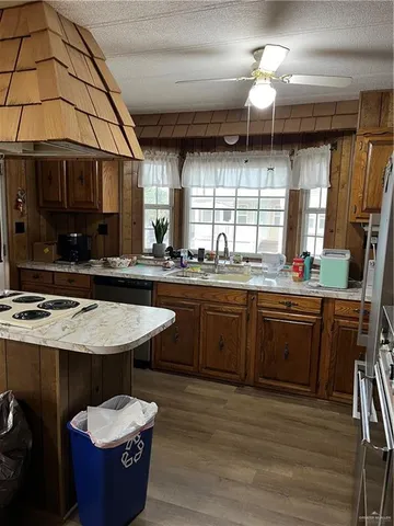 a kitchen with a sink a counter space appliances and cabinets