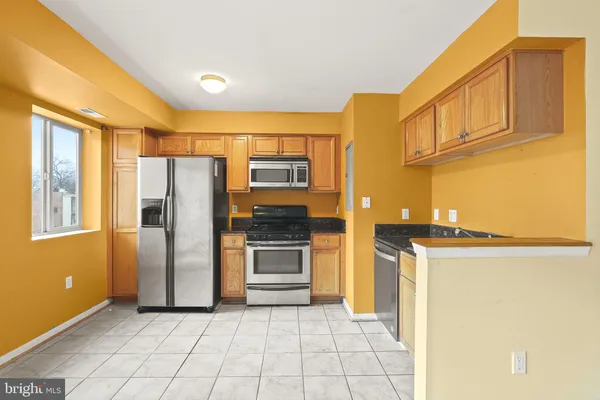 a kitchen with stainless steel appliances granite countertop a refrigerator and a stove