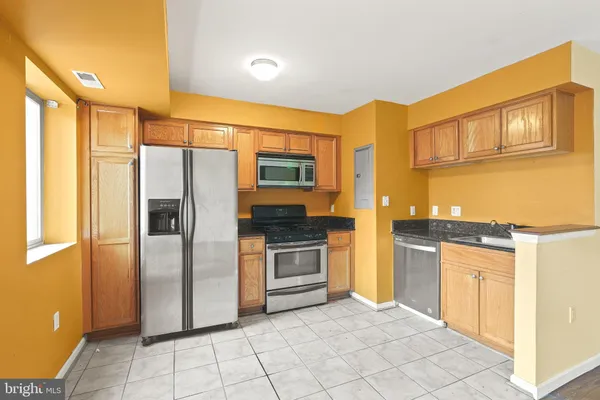 a kitchen with stainless steel appliances granite countertop a refrigerator and a stove top oven