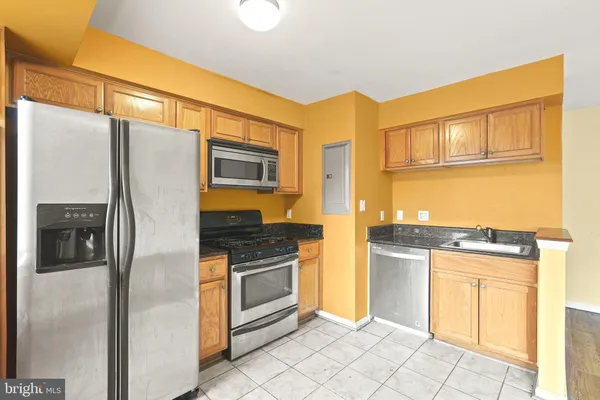 a kitchen with stainless steel appliances granite countertop a refrigerator and a stove top oven